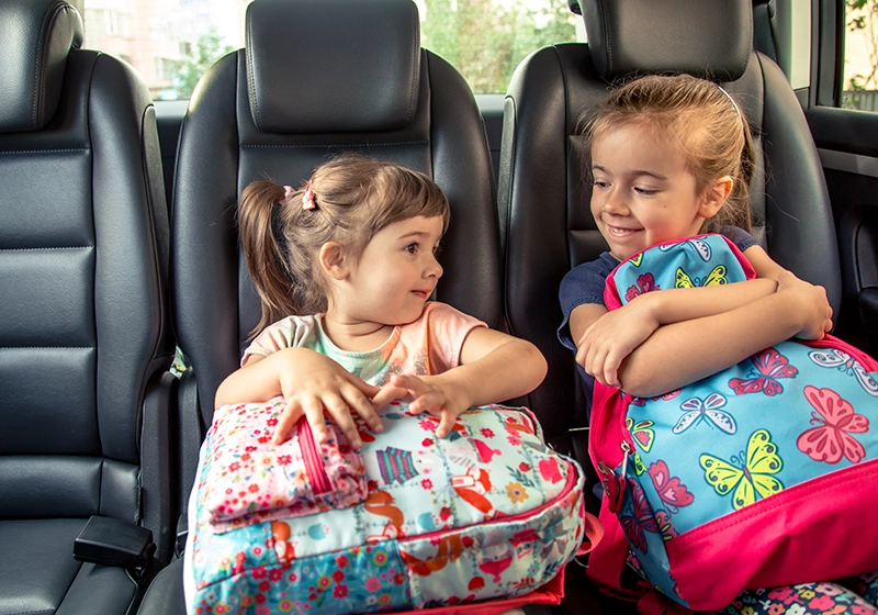 NIñas sentadas en la parte de atrás del Taxi.